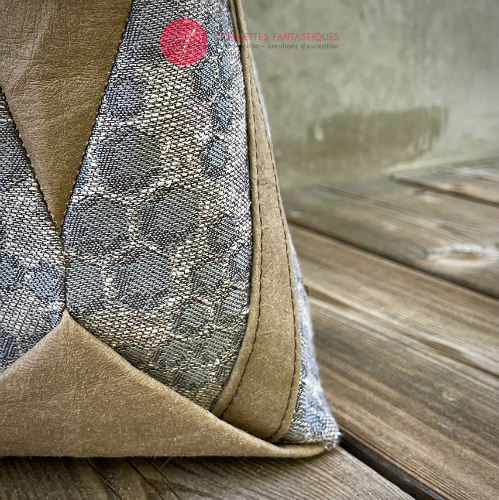 A shoulder bag made from gray babywearing wrap with a beehive and bees pattern, and brown washable paper.