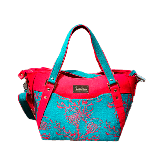 Un sac d'épaule fait avec du tissu d'écharpe rouge sang et vert émeraude au motif de chardons, de la gabardine rouge, de la toile de lin vert émeraude et du simili rouge.