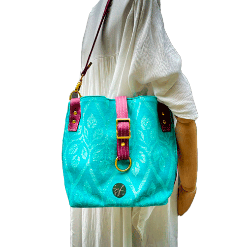 Un sac d'épaule en tissu d'écharpe turquoise et écru à motif de feuilles, simili prune et popeline menthe irisée.