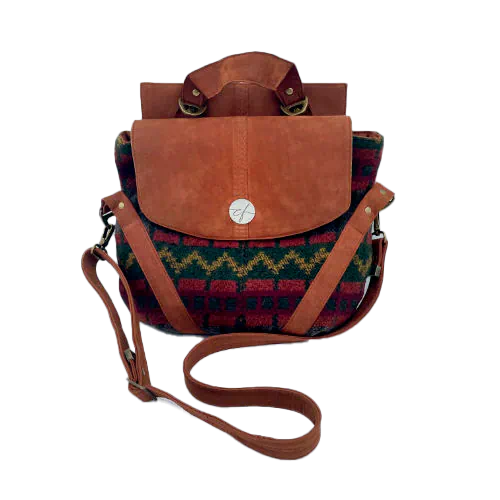 Un sac de taille moyenne, porté épaule, main, bandoulière ou dos, en suédine alezan et drap laine au motif géométrique, avec une doublure en viscose molletonée motif géométrique.