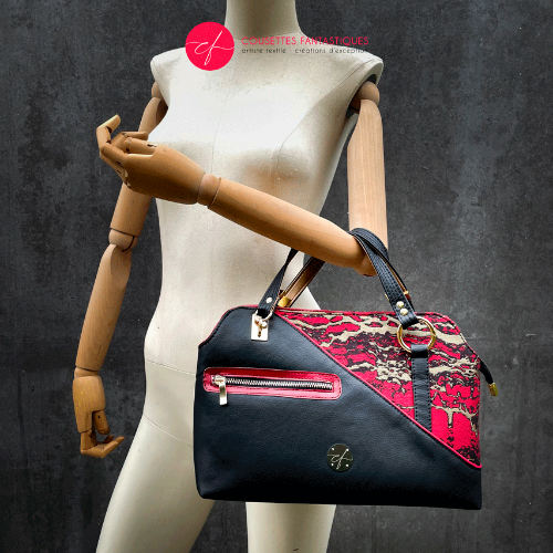 A handbag made of black, gold, and red faux leather and wrap fabric in the same tones, with a marbled pattern.