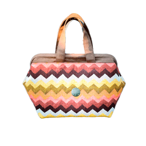 Un sac à main fait en tissu d'écharpe au motif chevron géant dans les tons d'automne (rose, marron, orange, jaune et blanc).