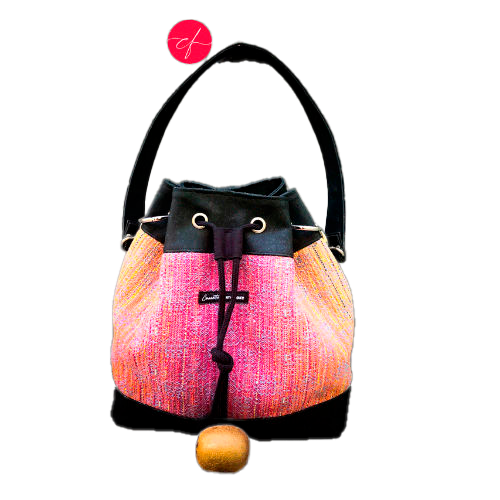 Un sac d'épaule fait en écharpe de portage dégradé miroir rose à bleu et liège noir.