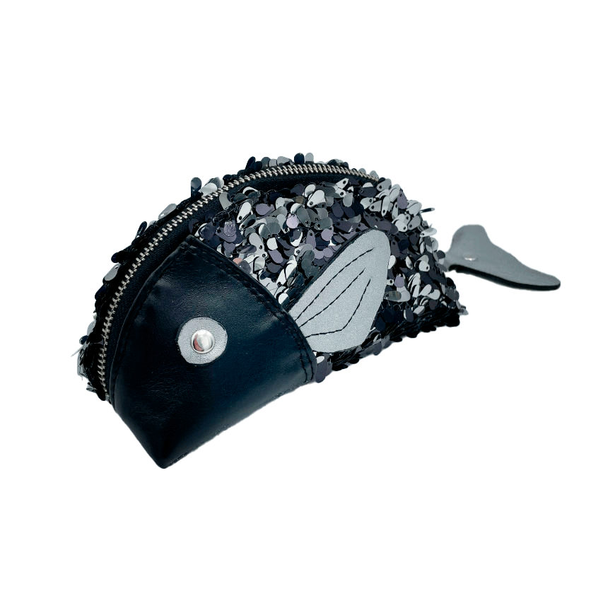 Une pochette zippée cousue dans du simili cuir noir, du tissu à sequins noirs et blancs, et du denim gris.