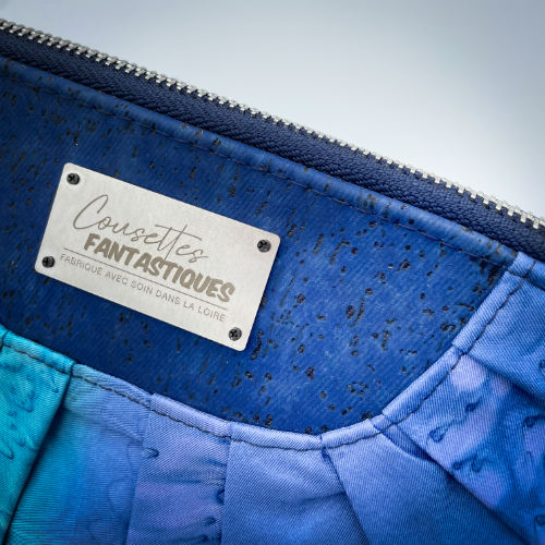 A zippered pouch sewn from a silk scarf in shades of blue, pleated and combined with royal blue cork.