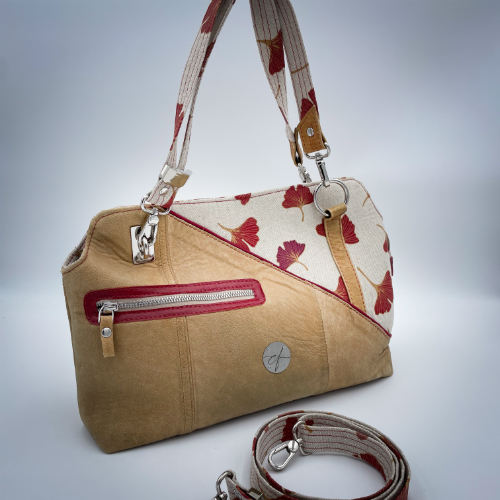 A handbag made of camel colored leather and a red Ginkgo Biloba leaves patterned polycotton canvas.