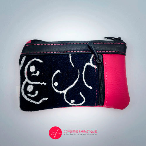 A mini zippered coin purse made from a patchwork of different materials: black and white babywearing wrap with stylized breast pattern, black lambskin leather, and fuchsia pink faux leather.