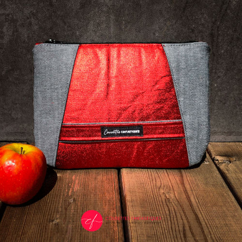 A zippered pouch sewn in gray reversible denim and metallic red, combined with bright red silk.