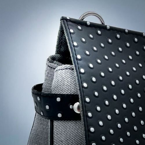 A boxy bag made with a silver dotted black vinyl and grey couture denim.