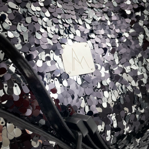 A large shoulder bag made from a black and silver sequin fabric, a grey couture denim, and a fine black faux leather.